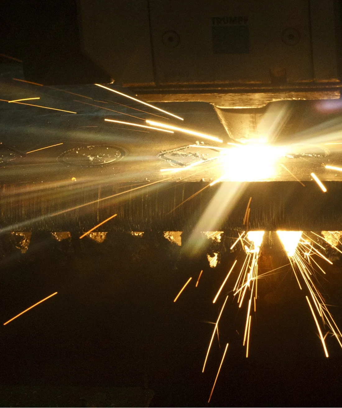 CNC-Laserschneiden von Blech mit Funkenflug bei der präzisen Metallbearbeitung